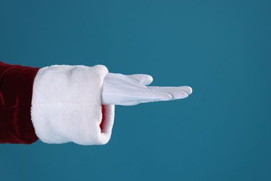 Photo of Santa Claus holding something on blue background, closeup