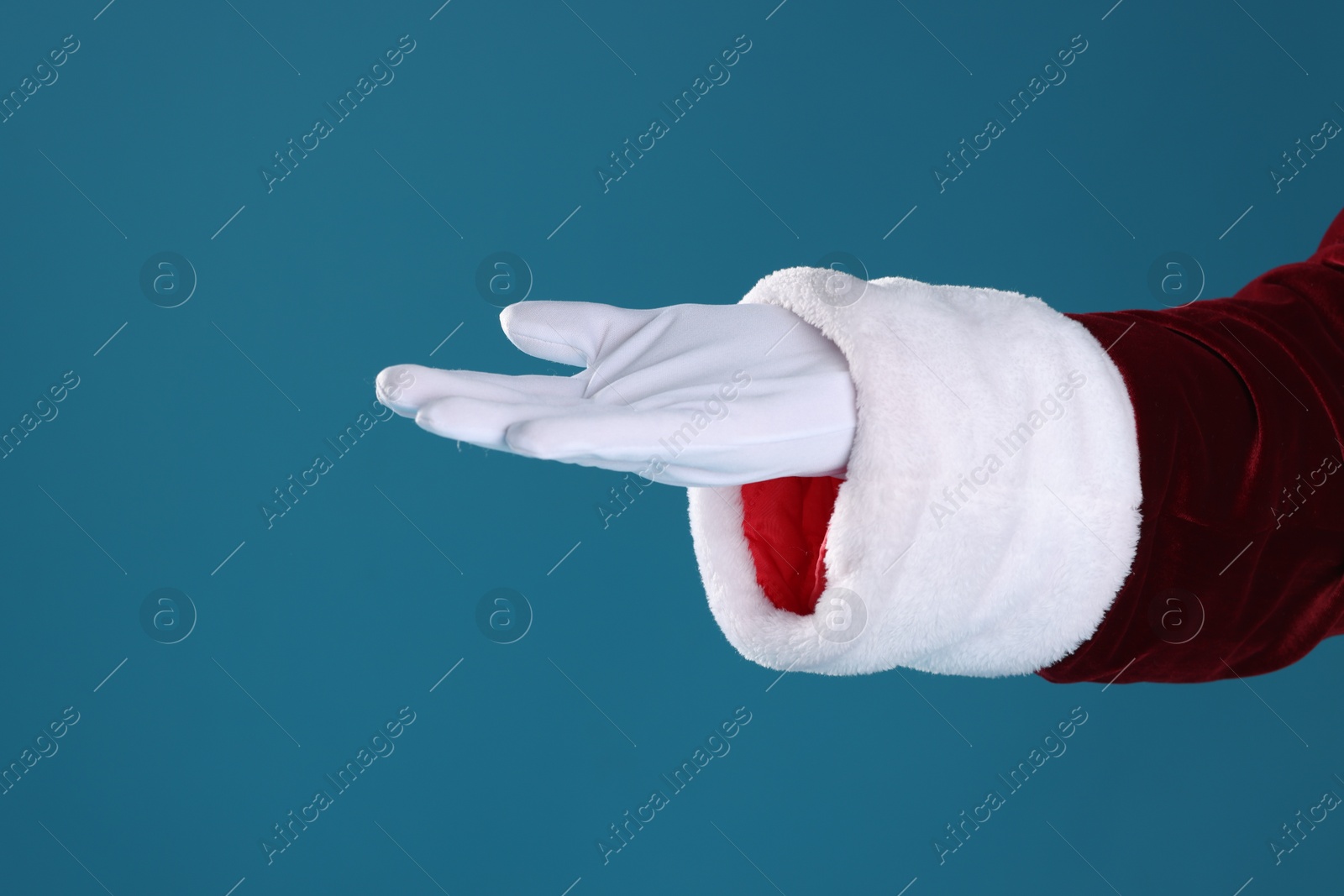 Photo of Santa Claus holding something on blue background, closeup