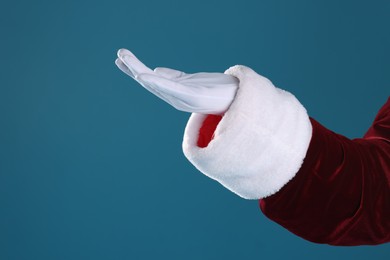 Photo of Santa Claus holding something on blue background, closeup