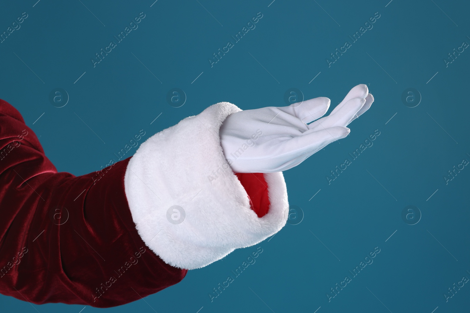 Photo of Santa Claus holding something on blue background, closeup