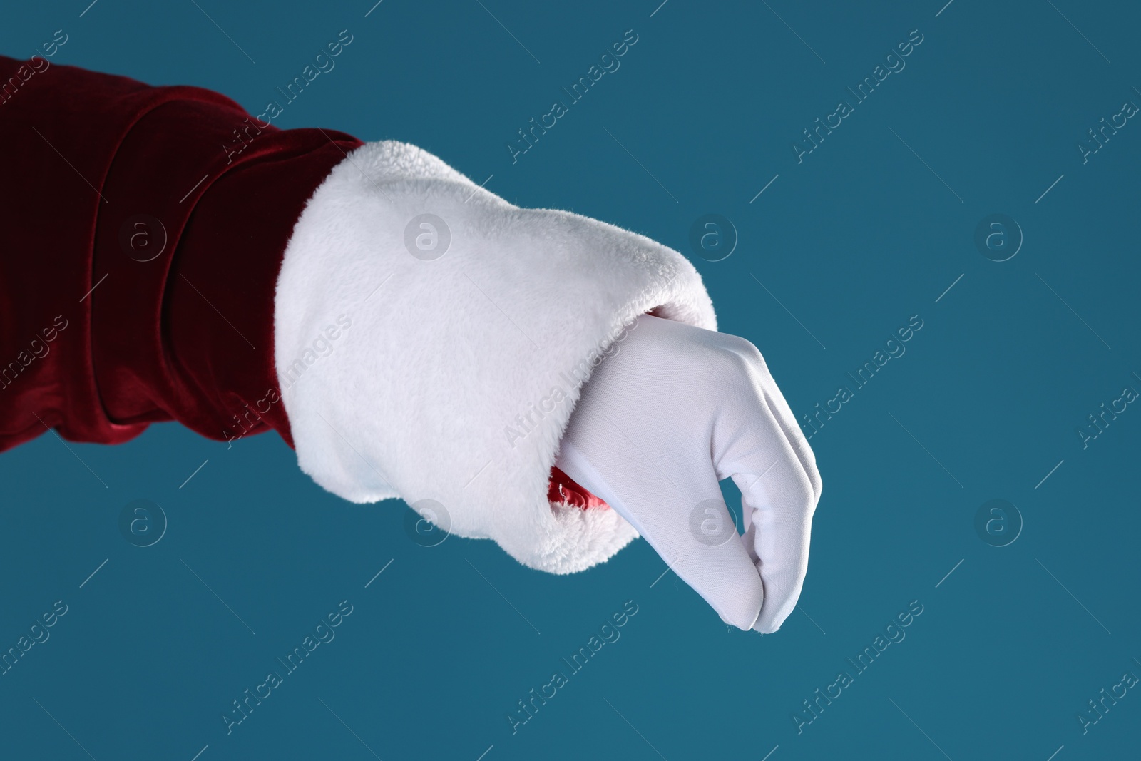 Photo of Santa Claus holding something on blue background, closeup