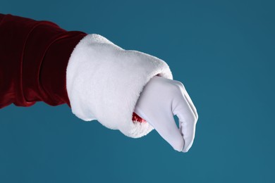 Santa Claus holding something on blue background, closeup