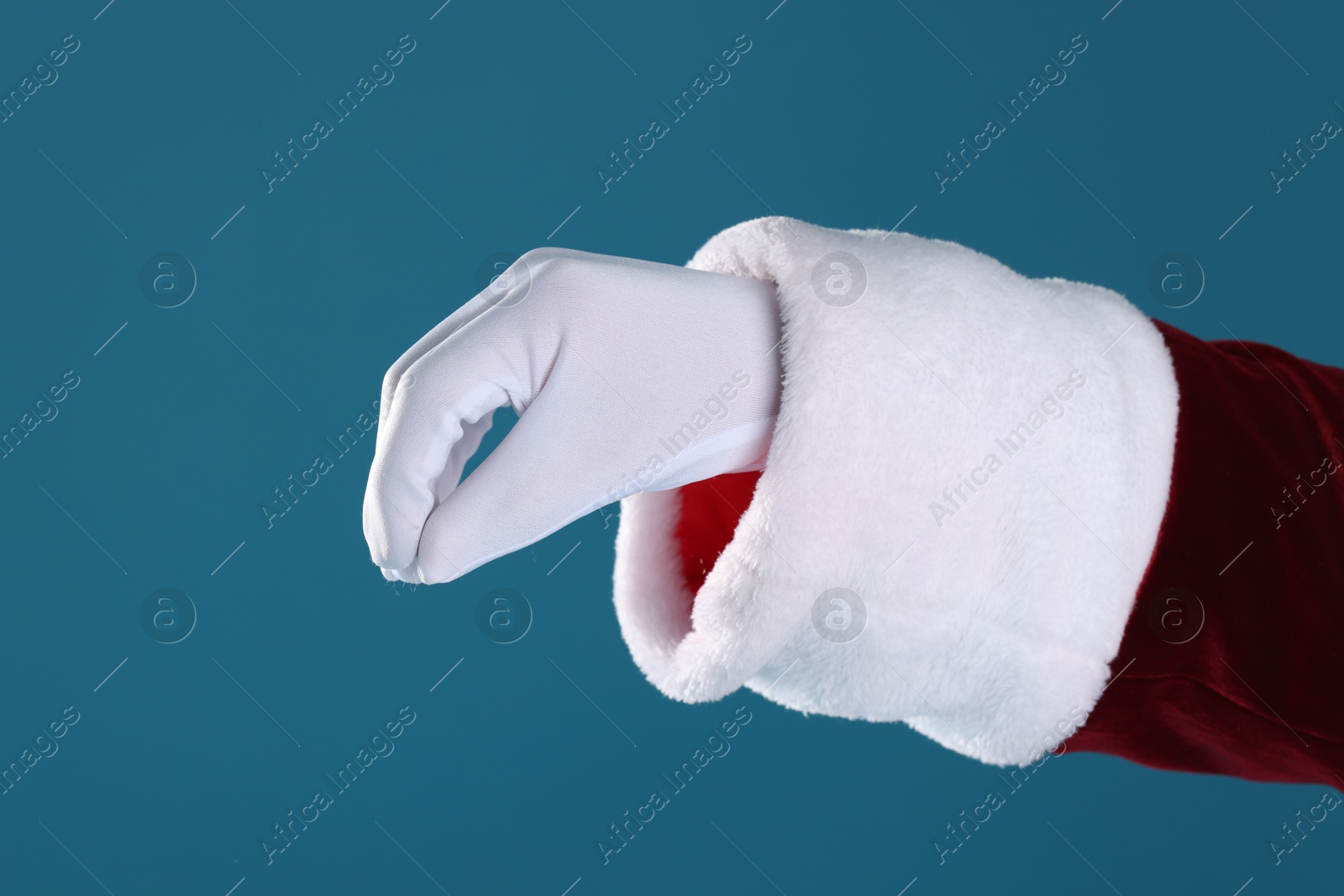 Photo of Santa Claus holding something on blue background, closeup