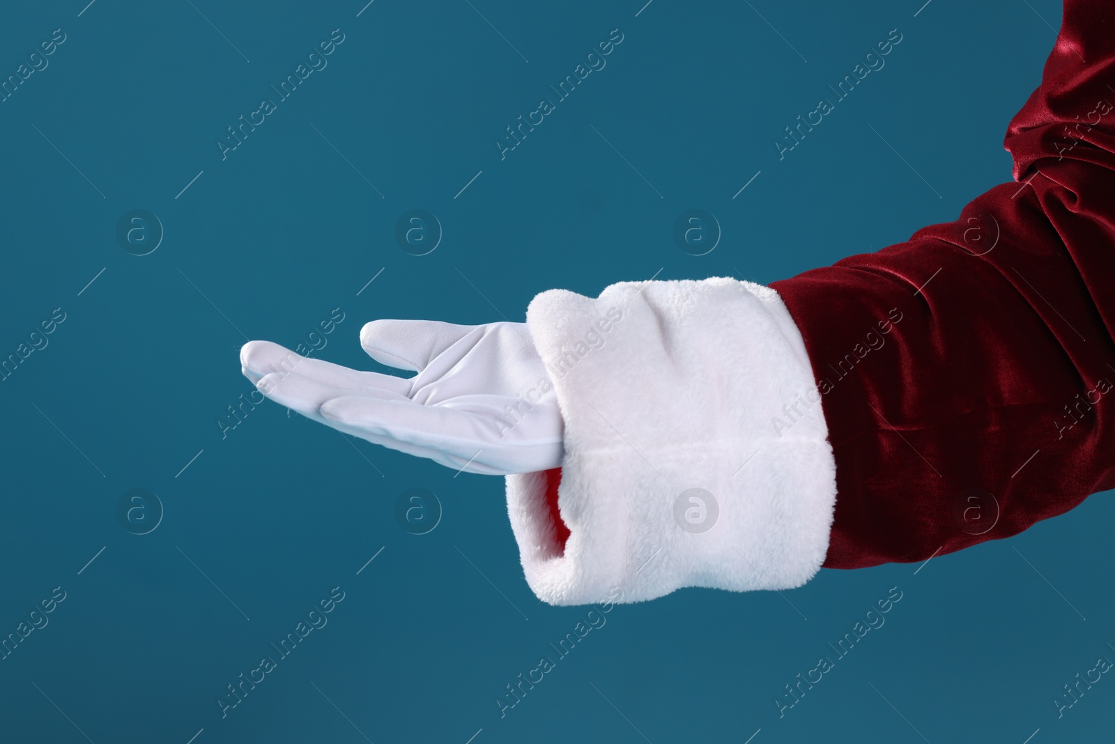 Photo of Santa Claus holding something on blue background, closeup