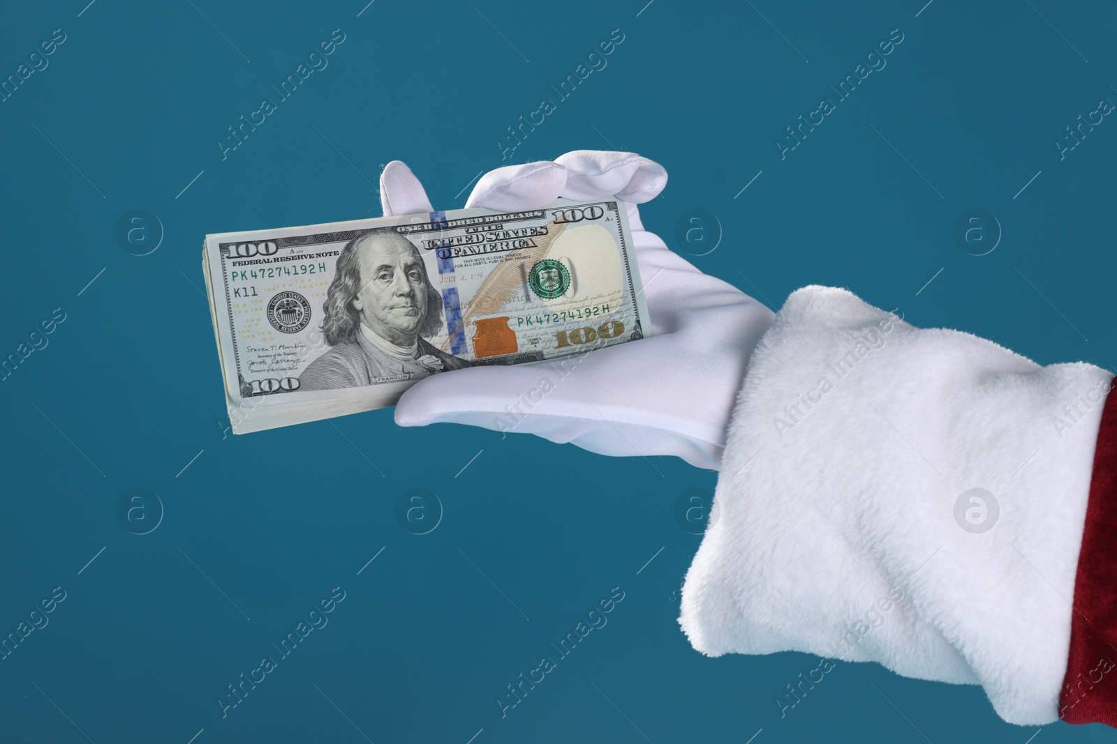 Photo of Santa Claus holding dollar banknotes on blue background, closeup