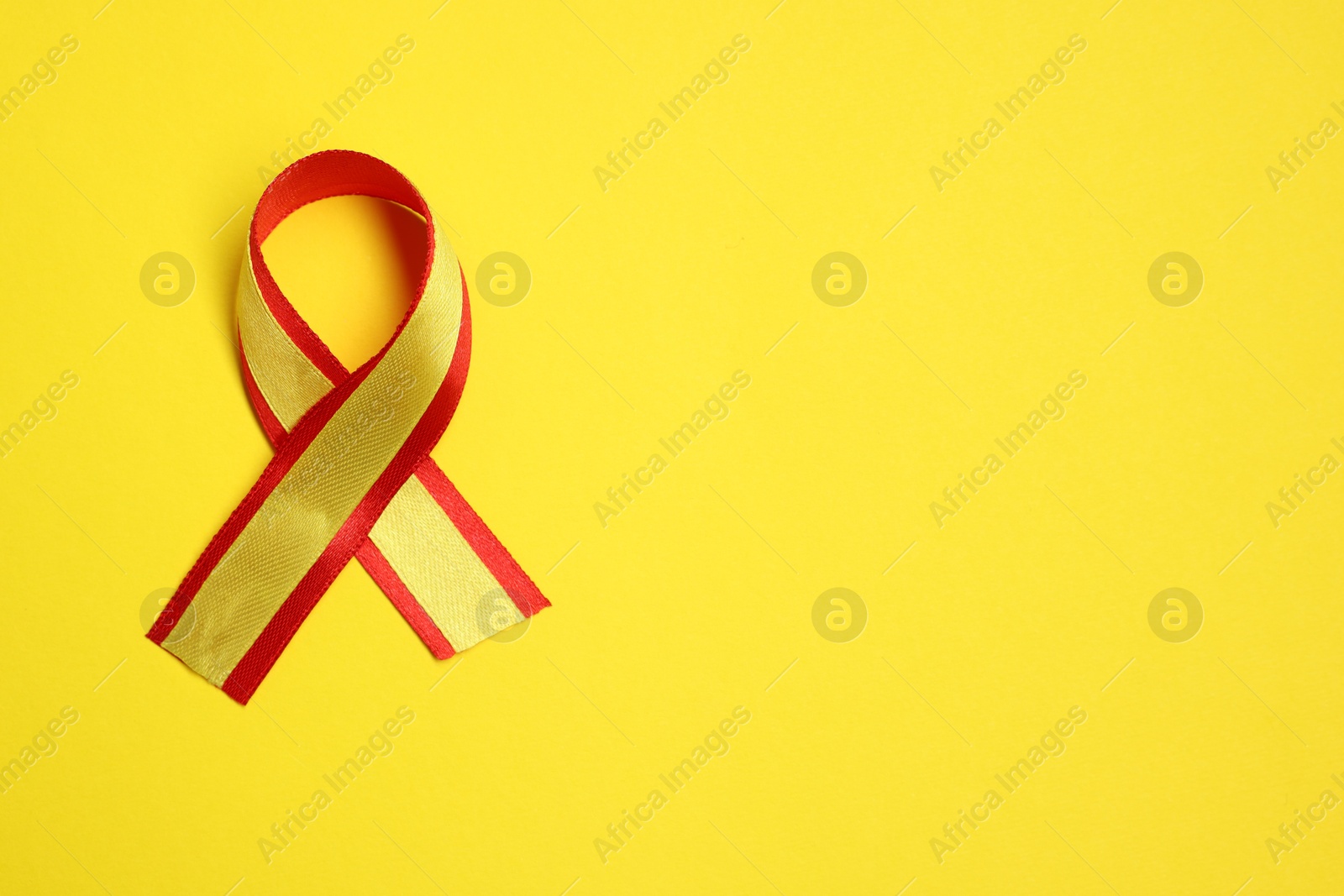 Photo of One colorful ribbon on yellow background, top view with space for text. Hepatitis C awareness