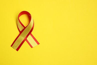 Photo of One colorful ribbon on yellow background, top view with space for text. Hepatitis C awareness