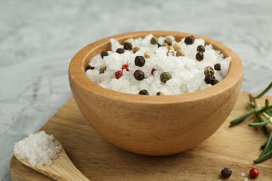 Photo of Sea salt and spices in bowl on gray table, closeup