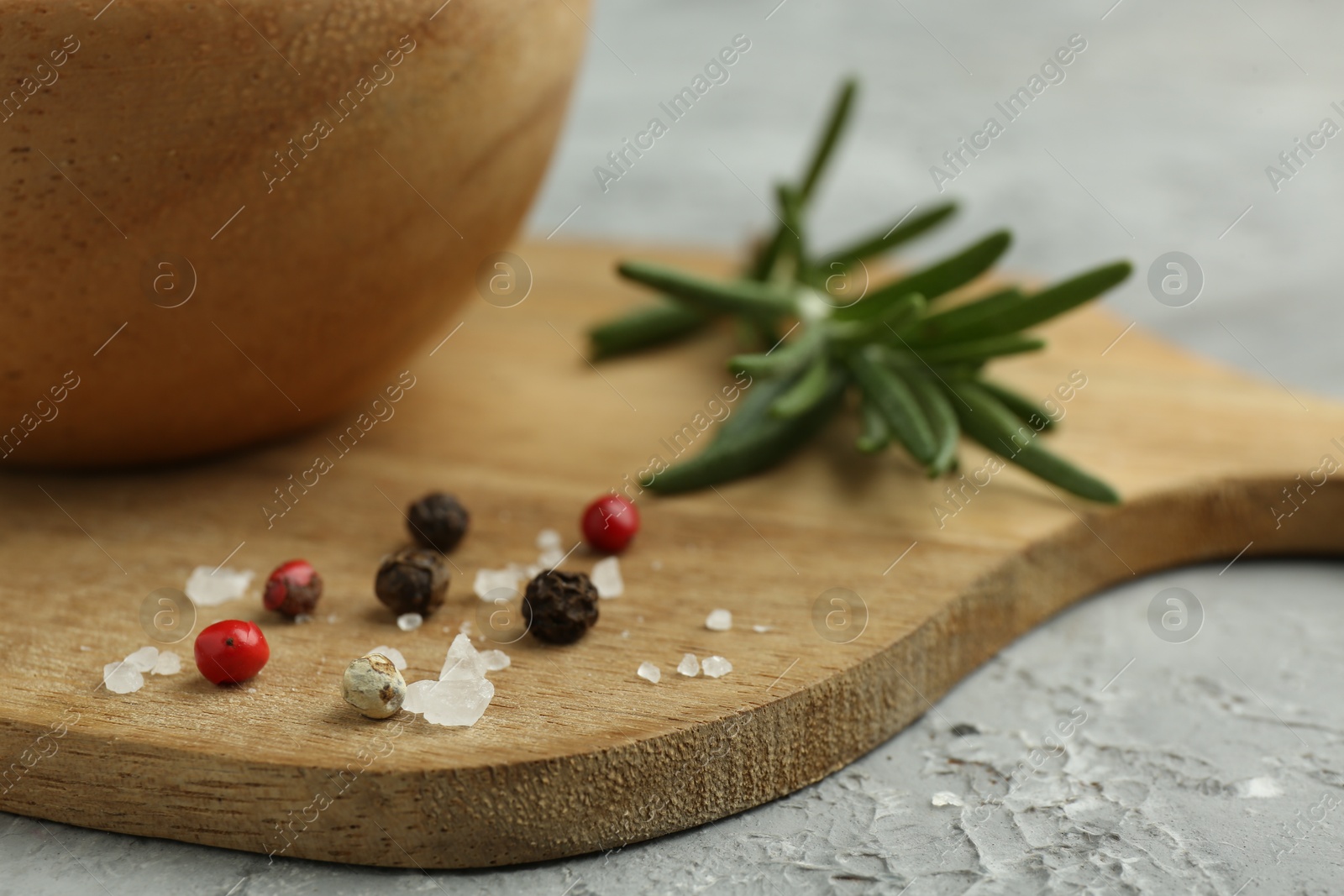 Photo of Sea salt and spices on gray textured table, closeup