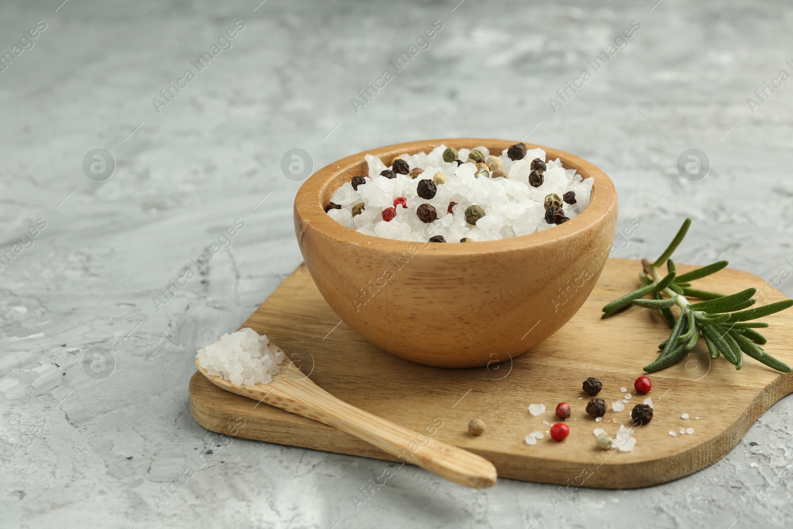 Photo of Sea salt and spices in bowl on gray textured table