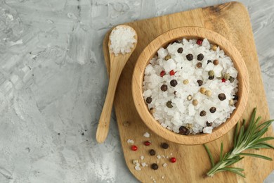 Photo of Sea salt and spices in bowl on gray textured table, top view. Space for text