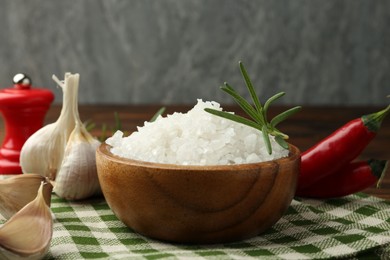 Photo of Sea salt in bowl and spices on table, closeup