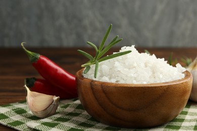 Photo of Sea salt in bowl and spices on table, closeup