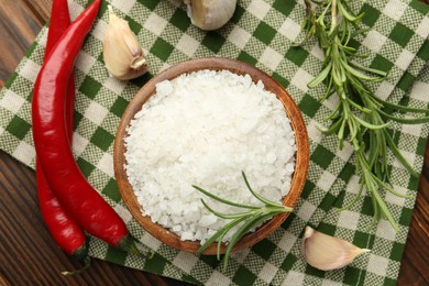 Photo of Sea salt in bowl and spices on table, flat lay