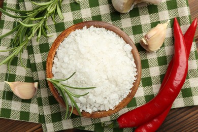 Photo of Sea salt in bowl and spices on table, flat lay