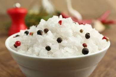 Photo of Sea salt and spices in bowl on brown table, closeup