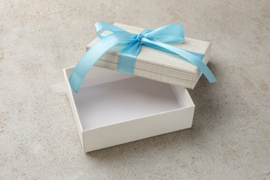 Empty gift box with bow on light grey table