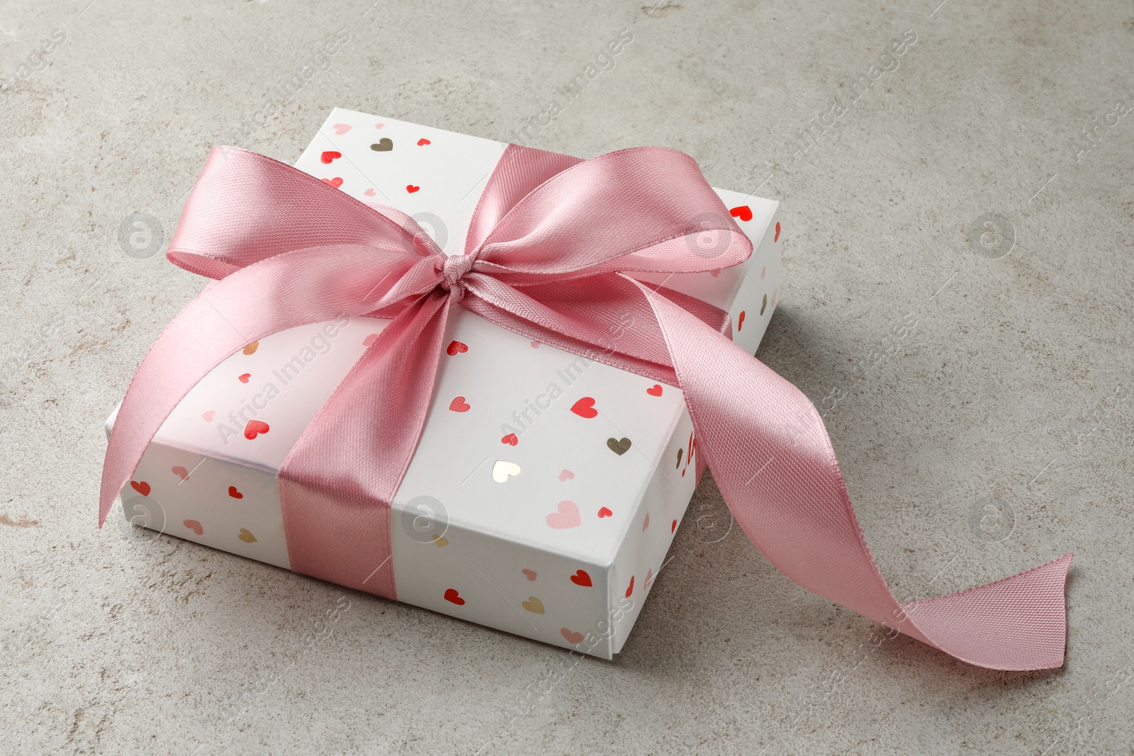 Photo of Beautiful gift box with pink ribbon on light grey table