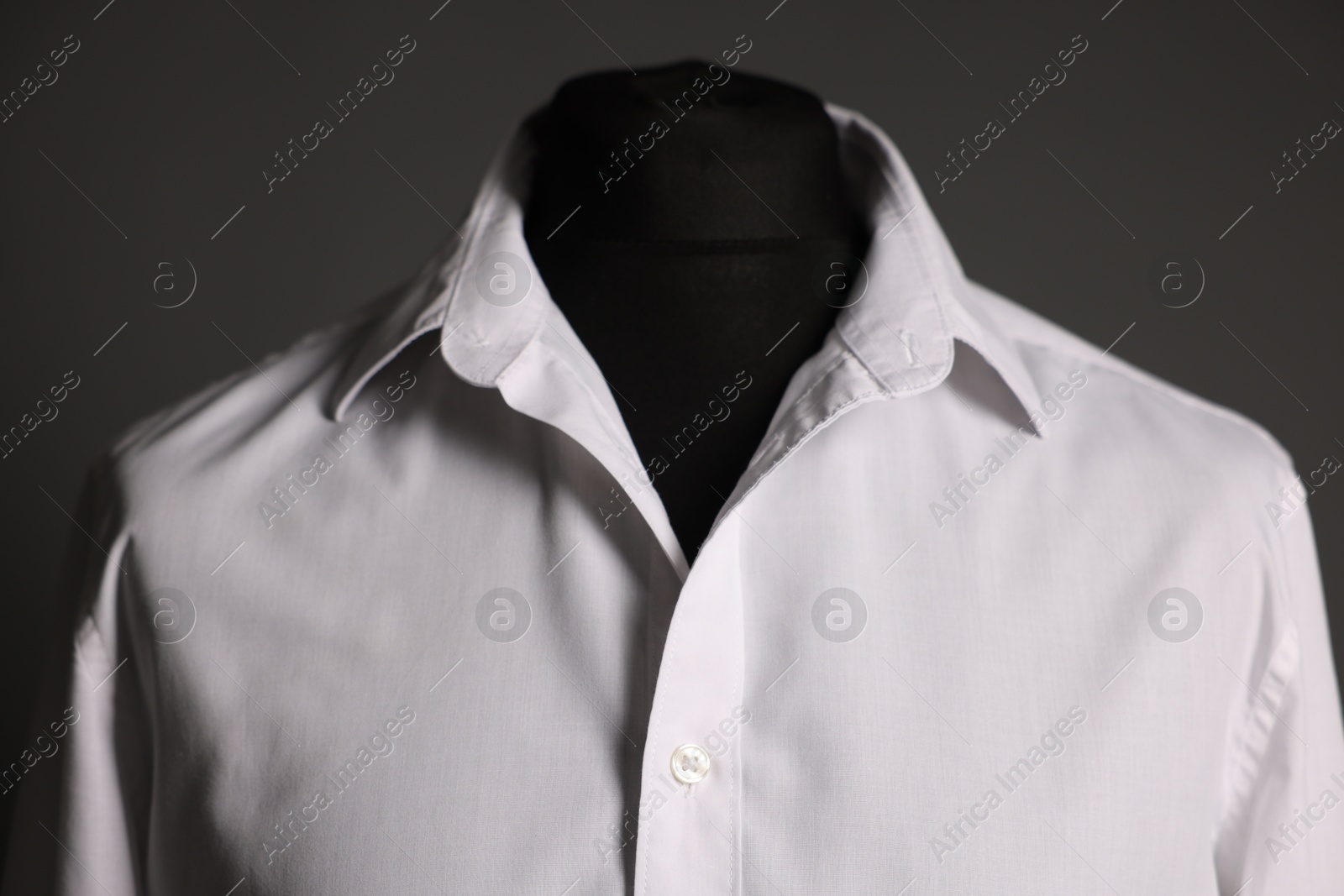 Photo of Male mannequin with white shirt on grey background, closeup