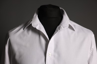 Male mannequin with white shirt on grey background, closeup