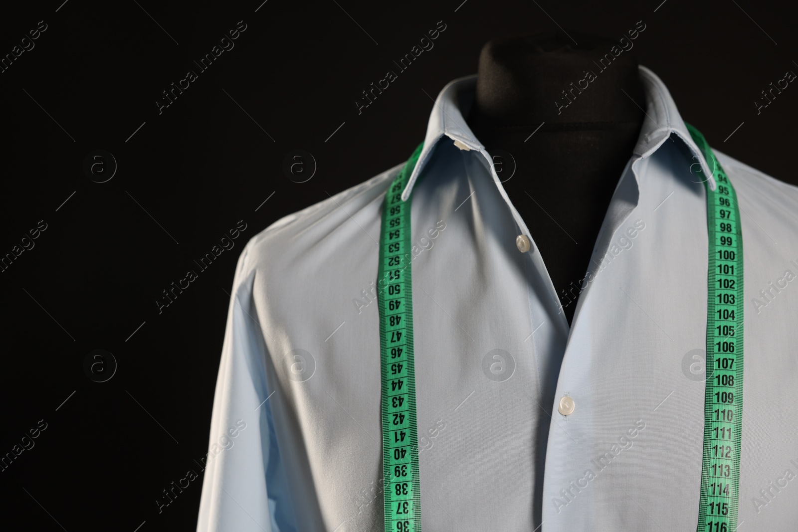 Photo of Male mannequin with shirt and measuring tape on black background