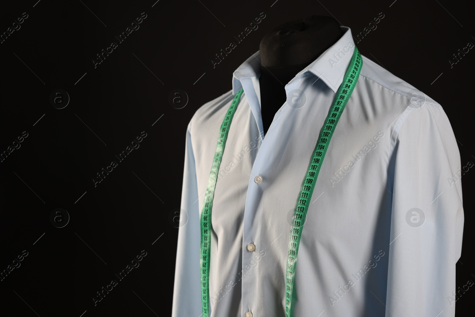 Photo of Male mannequin with shirt and measuring tape on black background, space for text