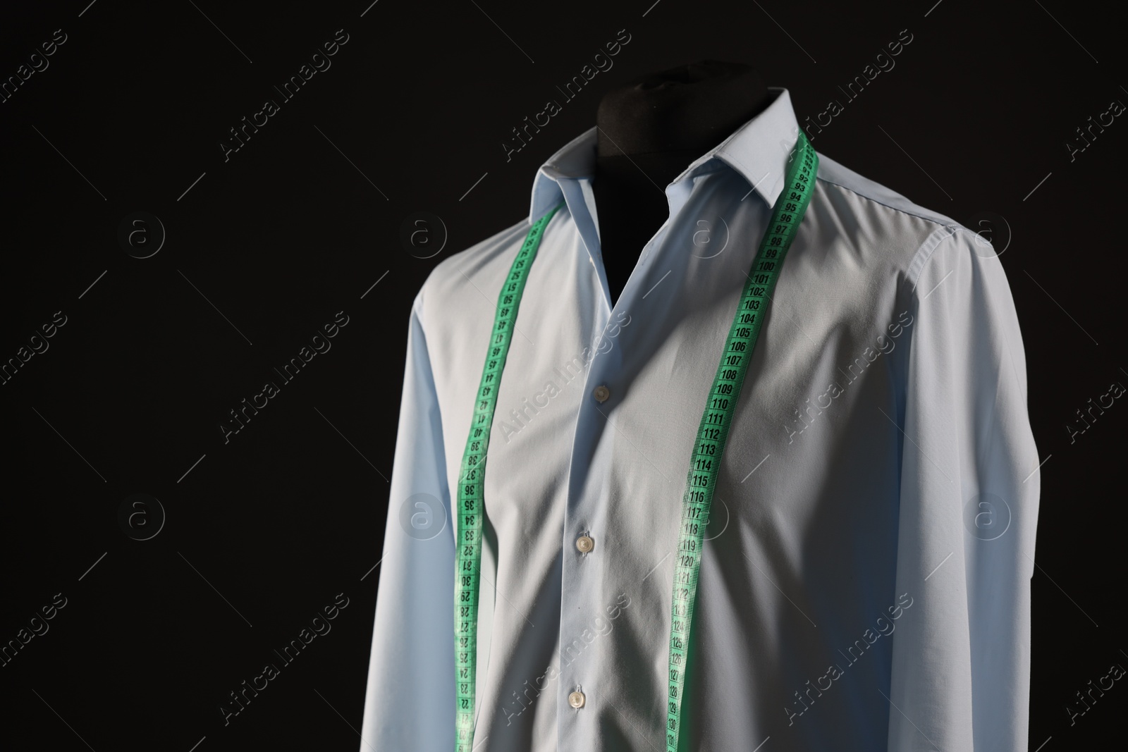 Photo of Male mannequin with shirt and measuring tape on black background, space for text