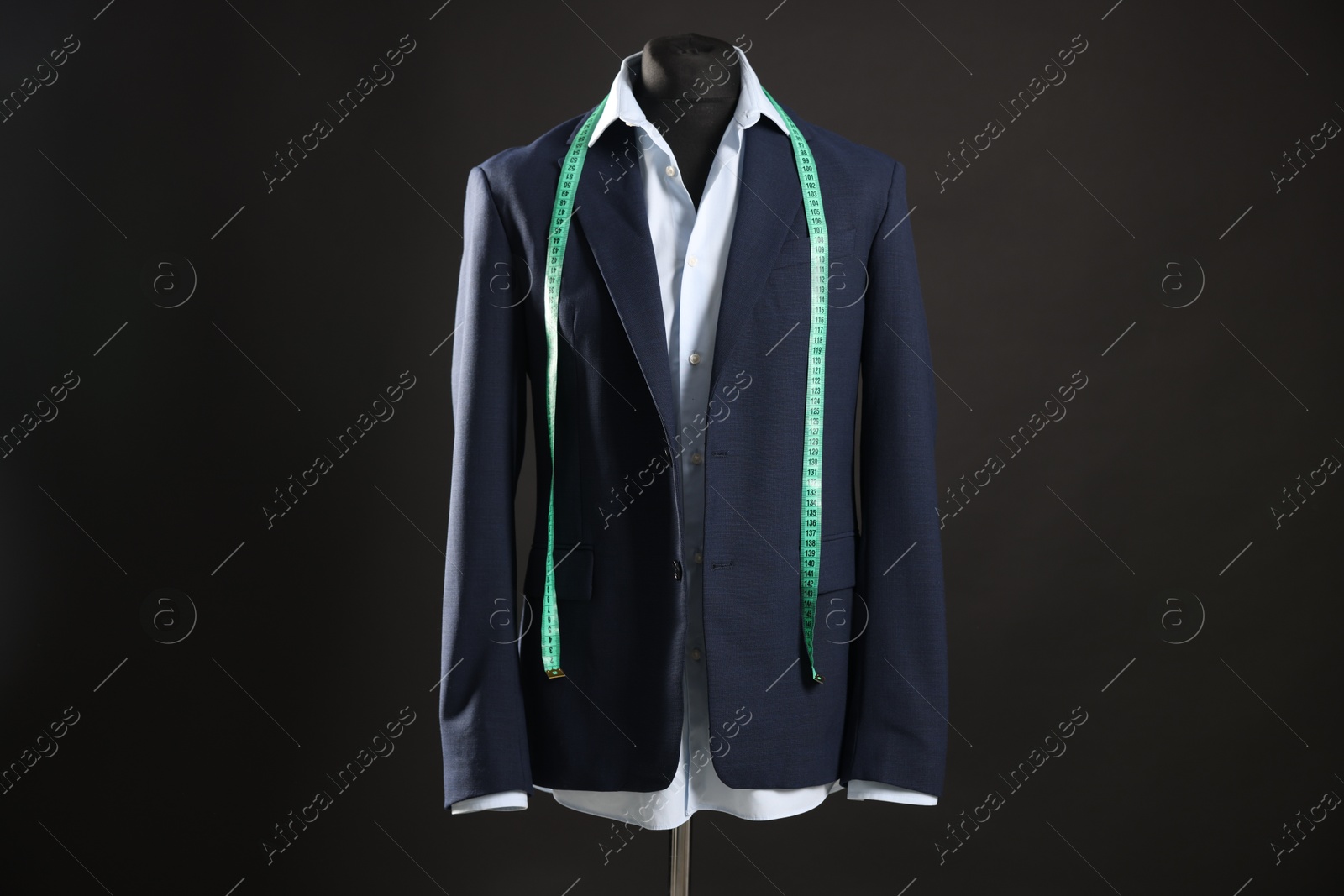 Photo of Male mannequin with jacket, shirt and measuring tape on black background