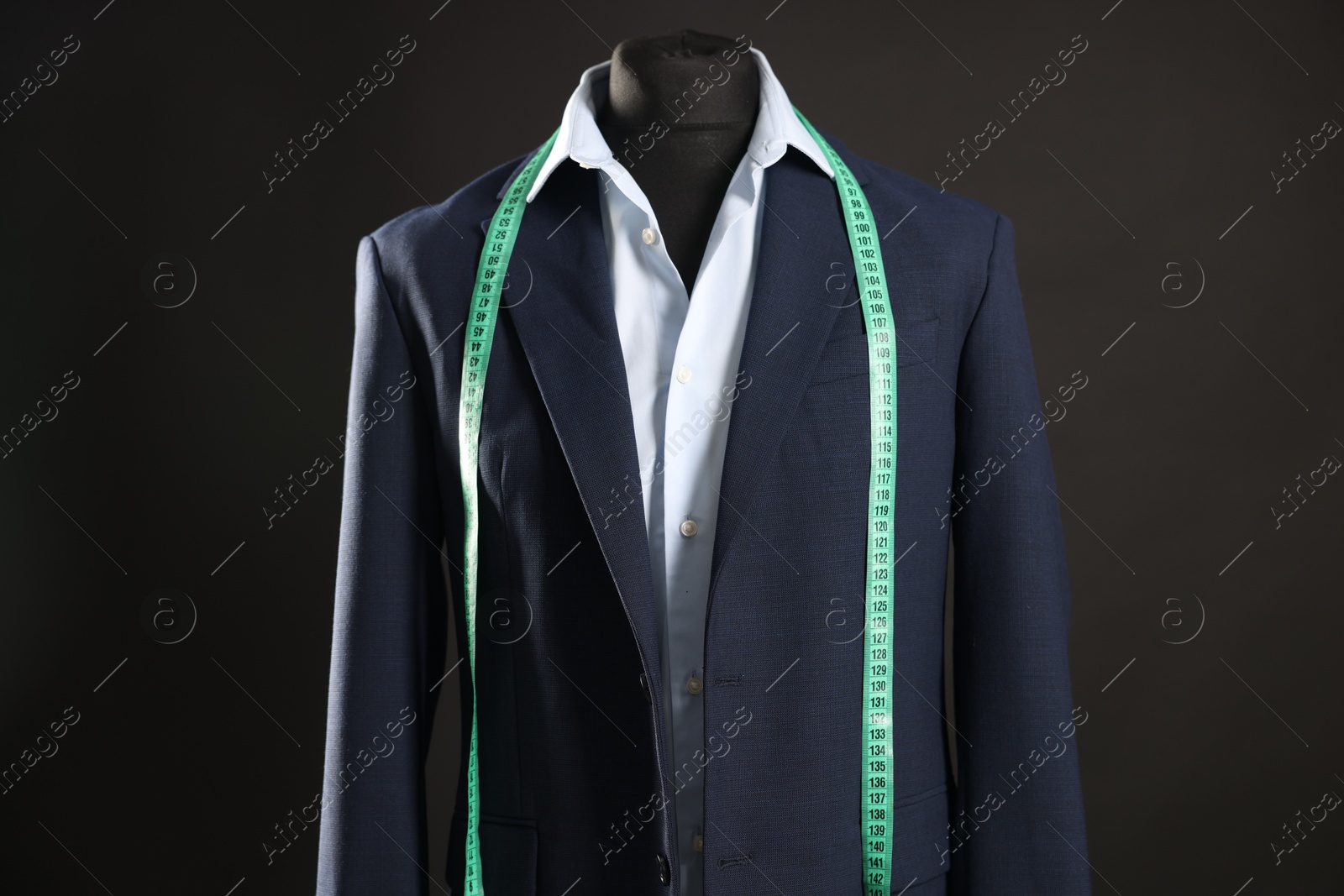 Photo of Male mannequin with jacket, shirt and measuring tape on black background