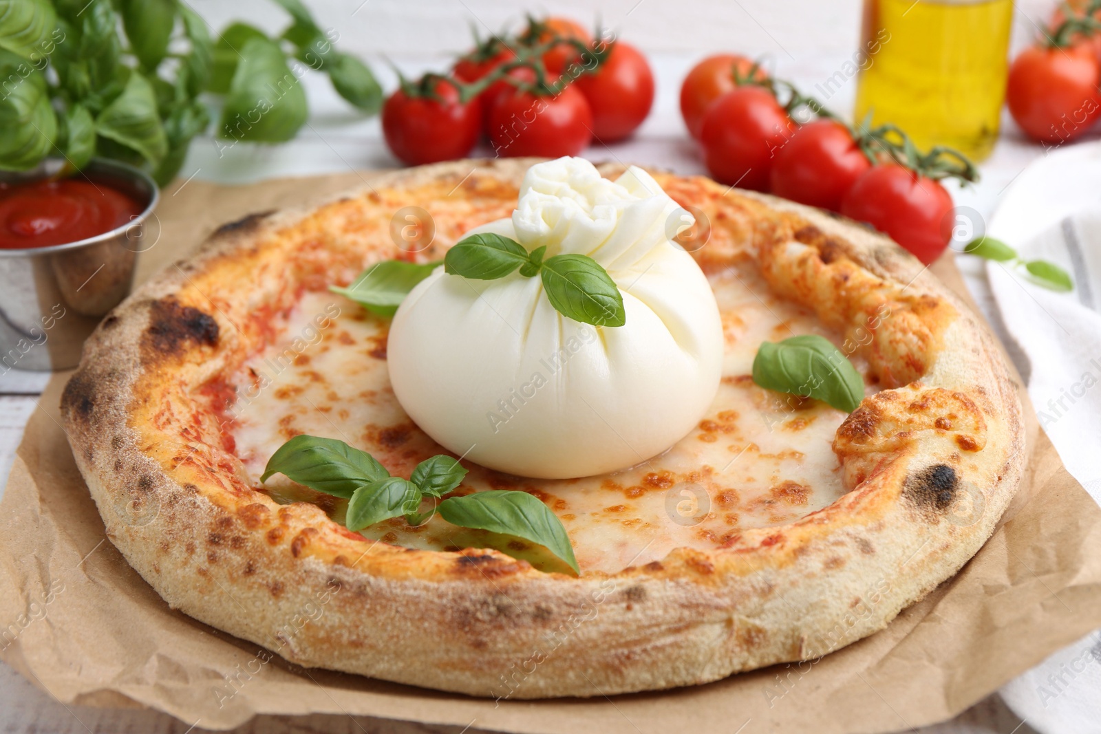 Photo of Delicious pizza with burrata cheese, basil, sauce and tomatoes on table, closeup