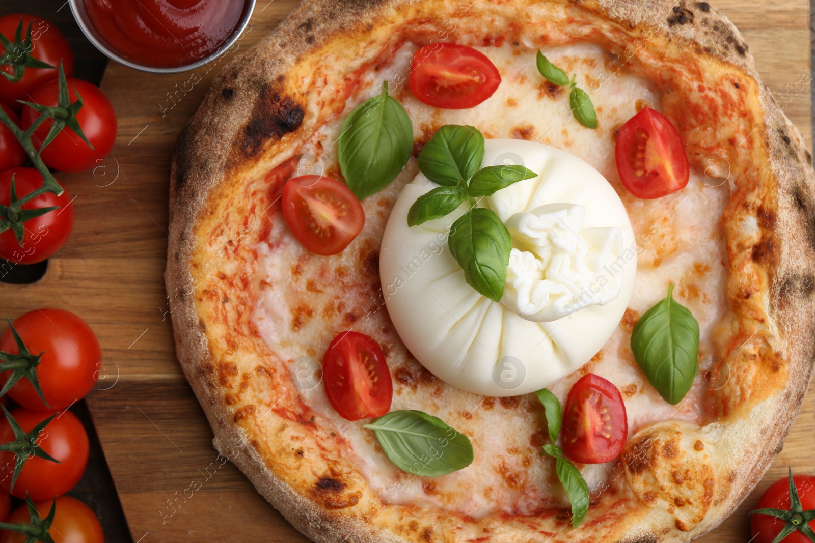 Photo of Delicious pizza with burrata cheese, basil, sauce and tomatoes on table, top view