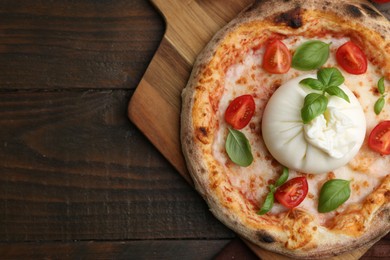 Photo of Delicious pizza with burrata cheese, basil and tomatoes on wooden table, top view. Space for text