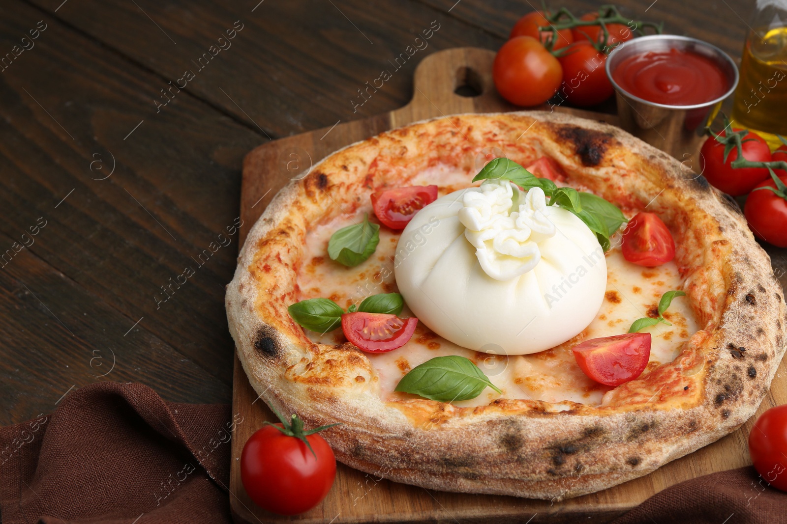 Photo of Delicious pizza with burrata cheese, basil, sauce and tomatoes on wooden table, closeup