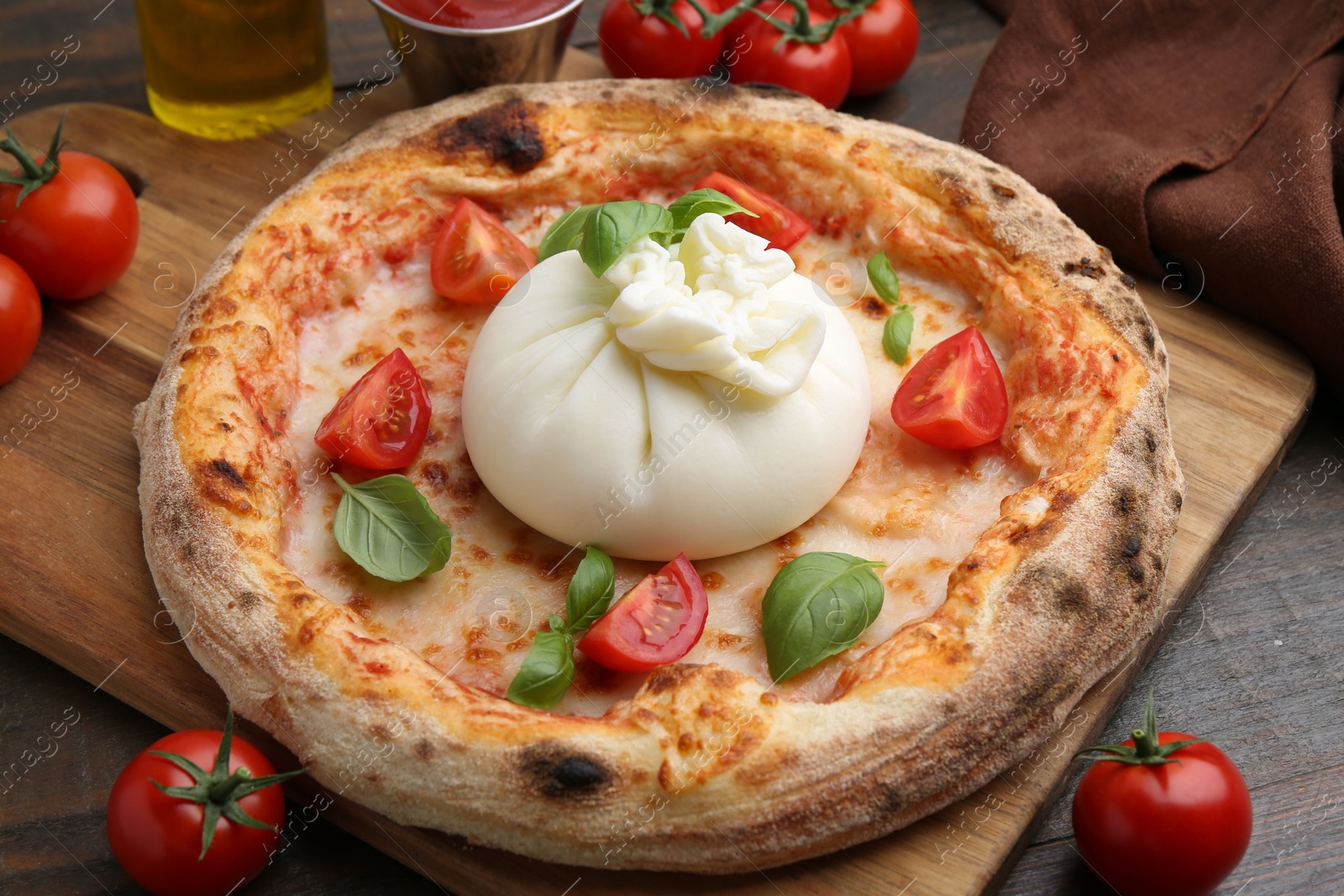 Photo of Delicious pizza with burrata cheese, basil and tomatoes on wooden table, closeup