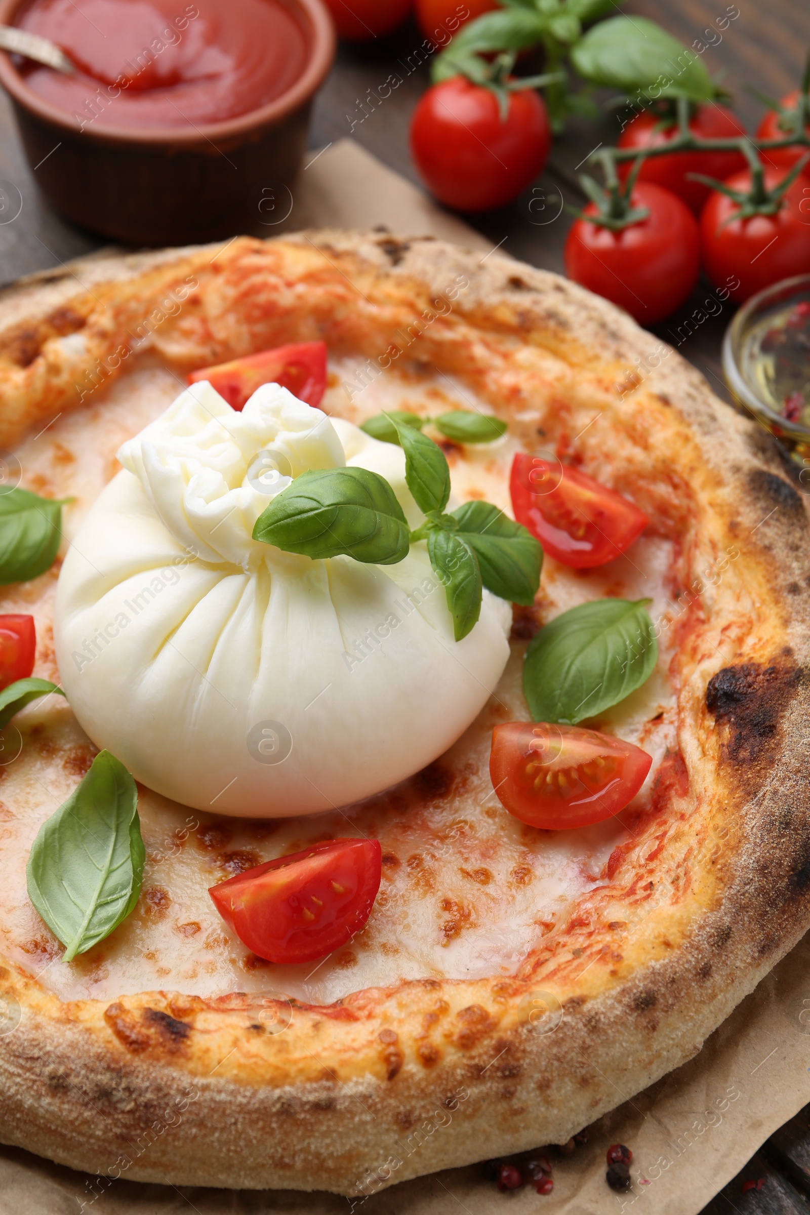 Photo of Delicious pizza with burrata cheese, basil and tomatoes on table, closeup