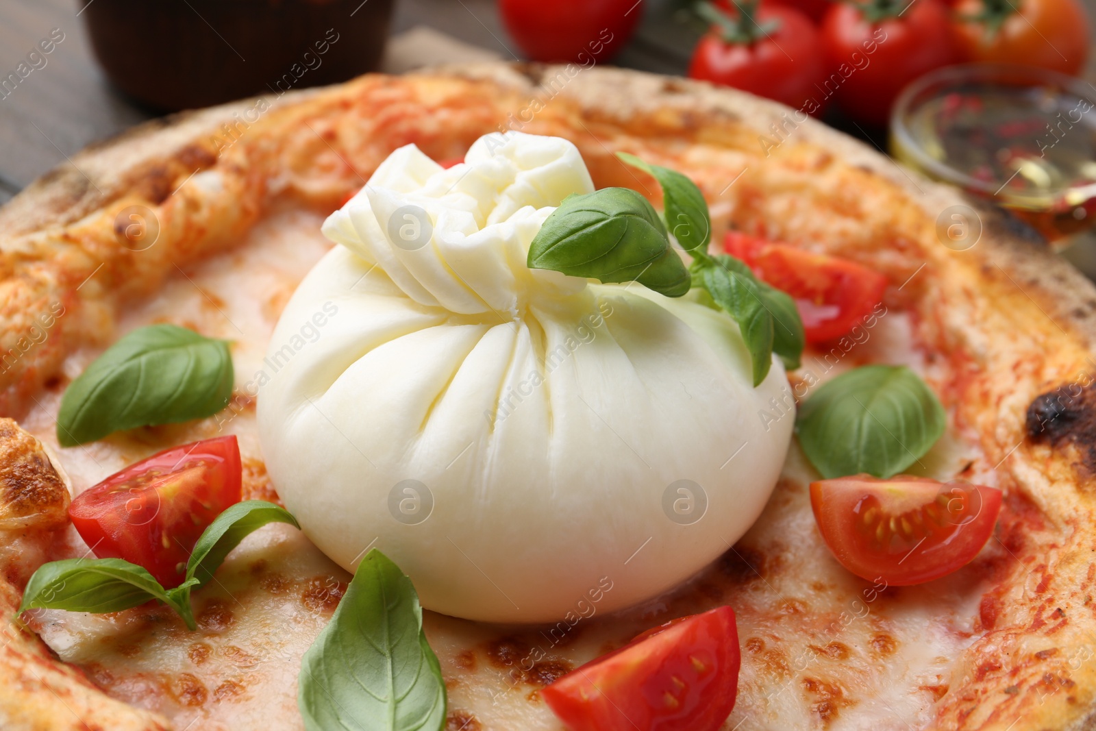 Photo of Delicious pizza with burrata cheese, basil and tomato on table, closeup