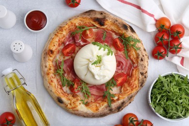 Delicious pizza with burrata cheese served on light grey table, top view