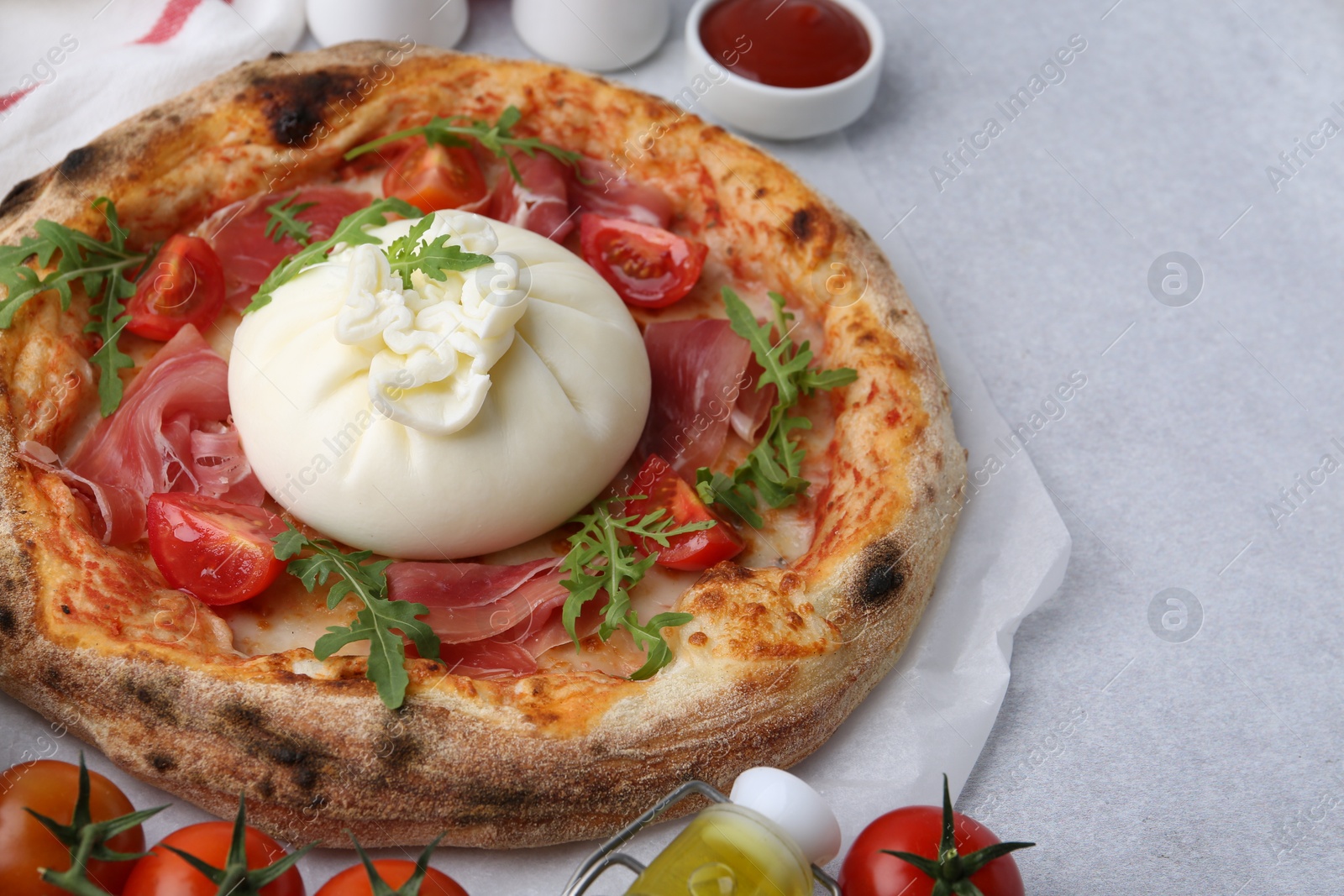 Photo of Delicious pizza with burrata cheese served on light grey table, closeup