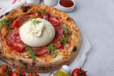 Delicious pizza with burrata cheese served on light grey table, closeup