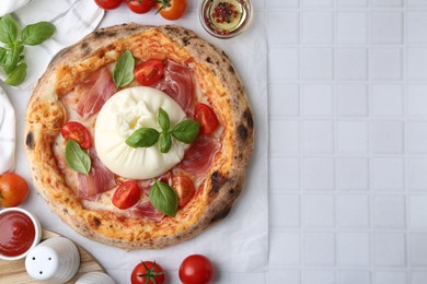 Photo of Delicious pizza with burrata cheese served on white tiled table, top view. Space for text