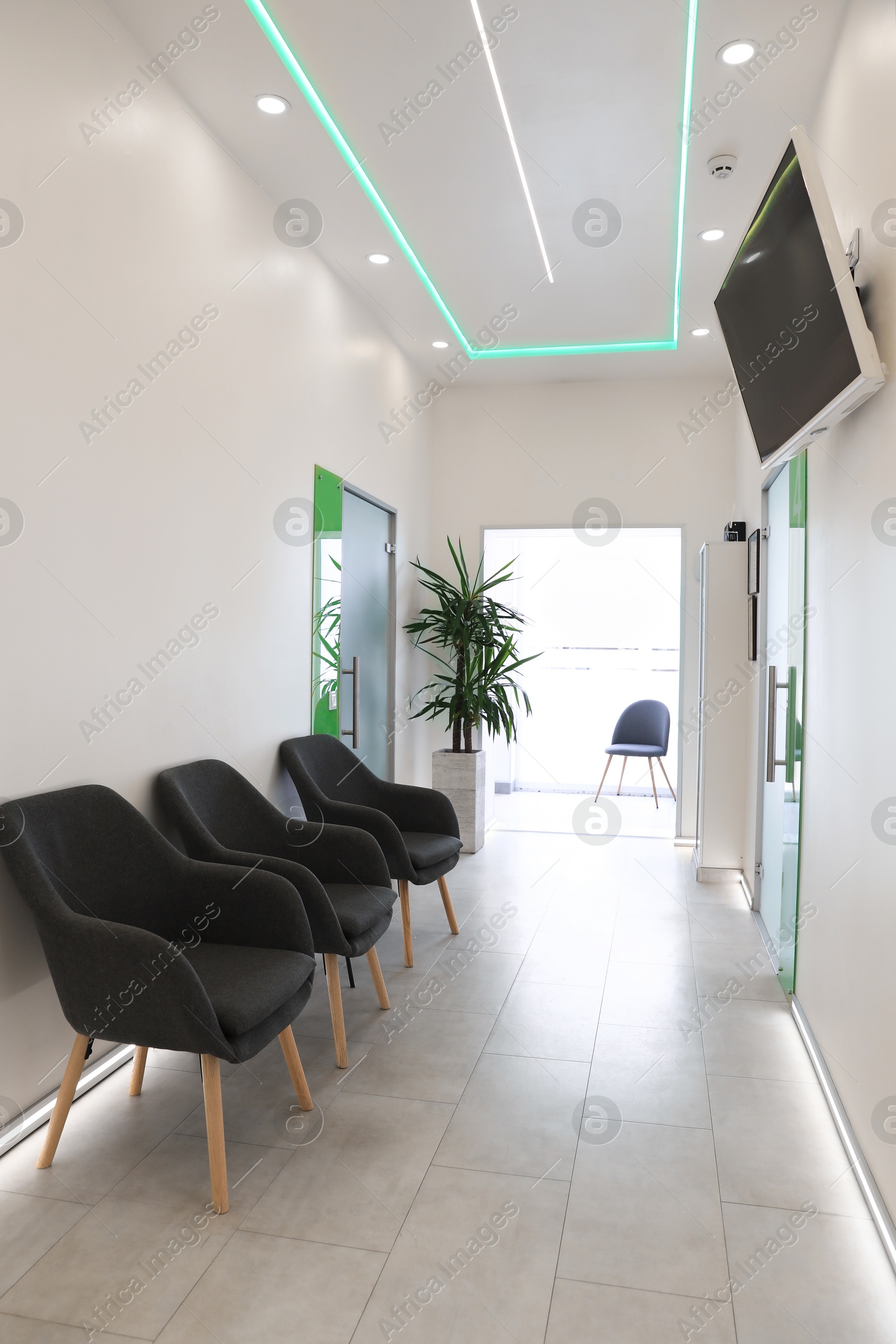 Photo of Empty hospital corridor with doors and chairs