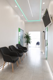 Photo of Empty hospital corridor with doors and chairs