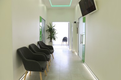 Photo of Empty hospital corridor with doors and chairs