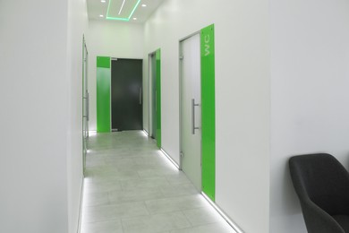 Photo of Empty hospital corridor with doors and chairs