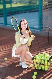 Beautiful woman with tennis racket and ball on court