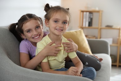 Photo of Cute little sisters spending time together at home