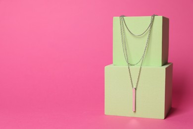 Photo of Stylish presentation of beautiful necklace on pink background. Space for text