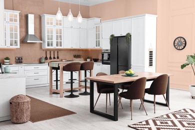 Image of Bar stools, tables and other furniture in stylish kitchen