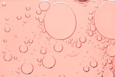 Cosmetic oil on peach fuzz color background, macro view