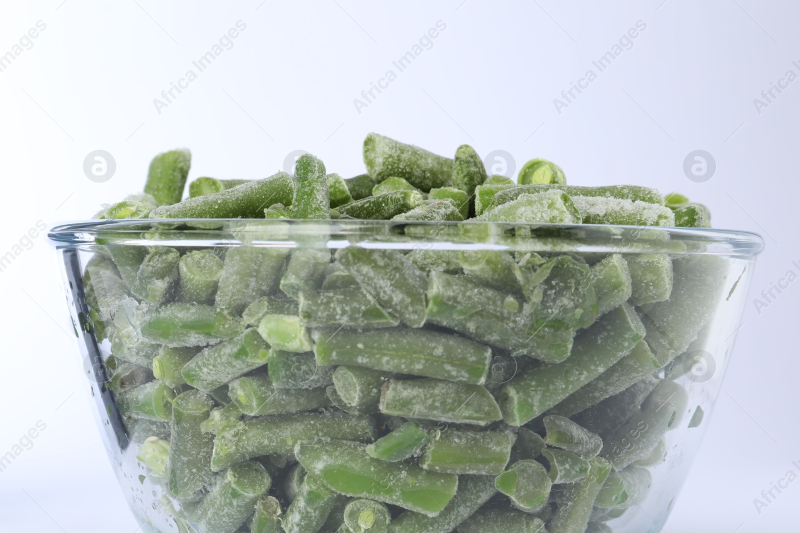 Photo of Frozen green beans in bowl isolated on white